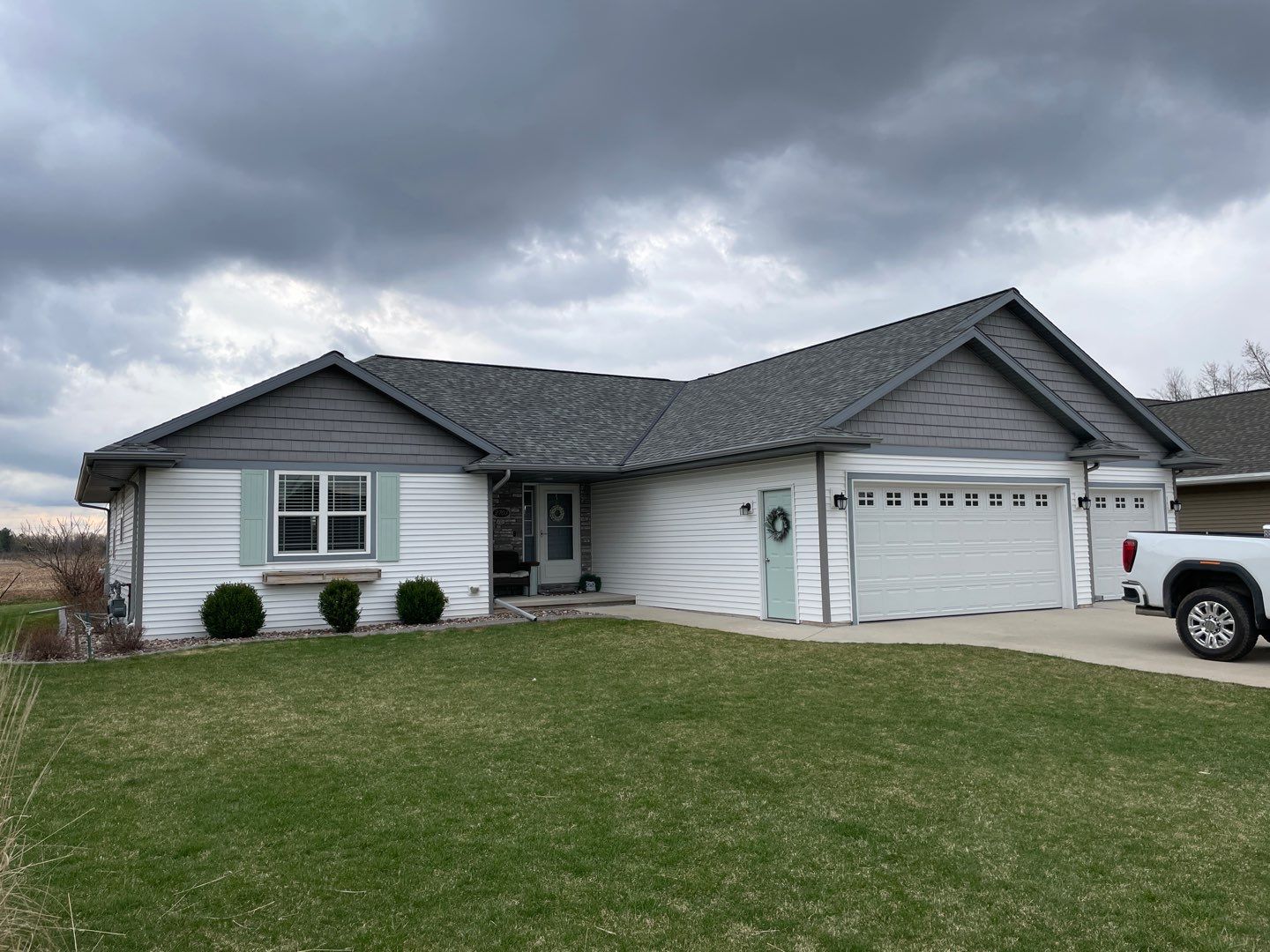 White single story home with white and grey siding with matching grey shingles in Green Bay, WI