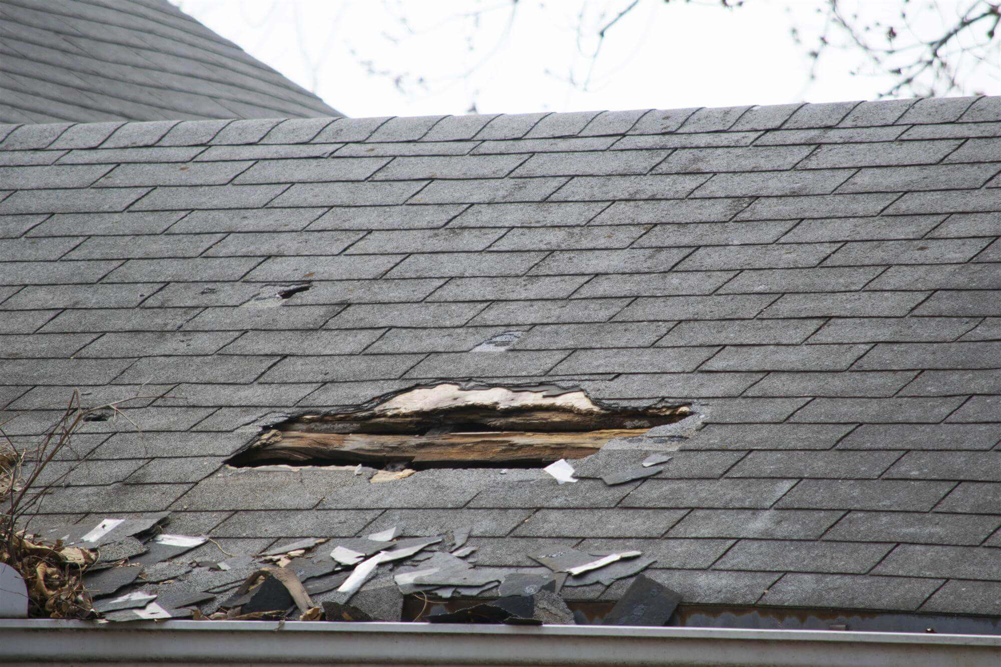 Asphalt shingle roof with severe storm damage in Green Bay, Wisconsin