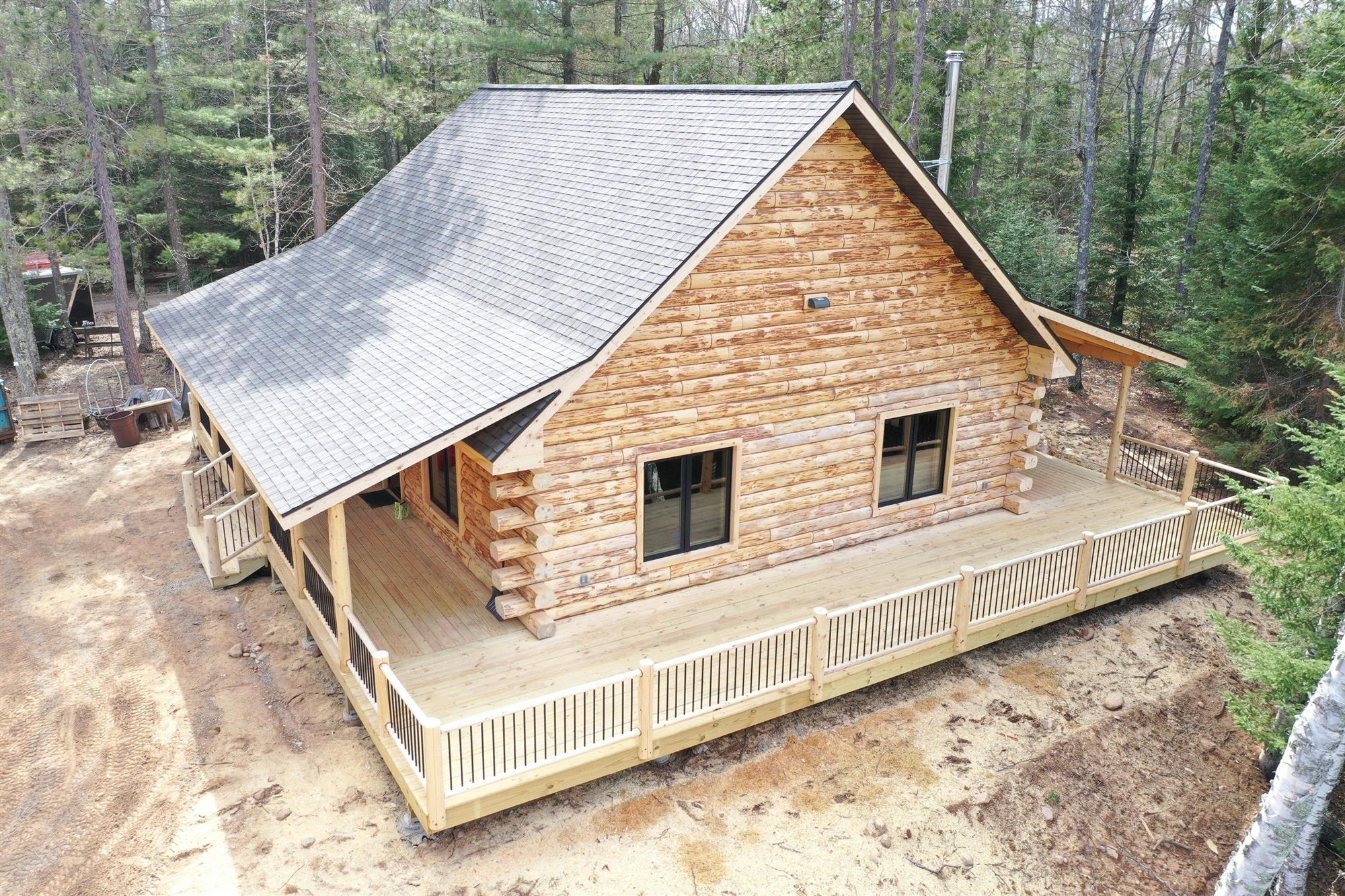 Log home with a new roof installed by Overhead Solutions in Green Bay, WI