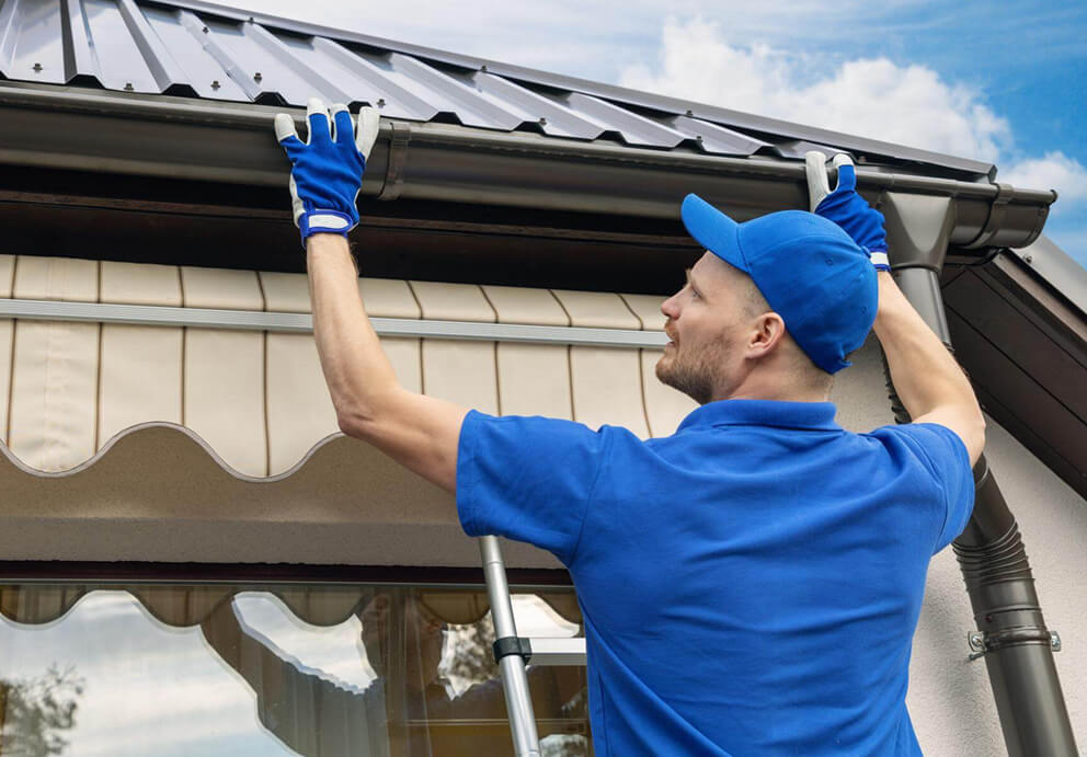 Roofing contractor replacing gutter after new metal roof replacement in Kaukauna, WI